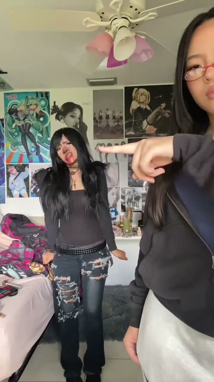 Twin dance in a poster-filled bedroom; the front dancer points and the back dancer hops.